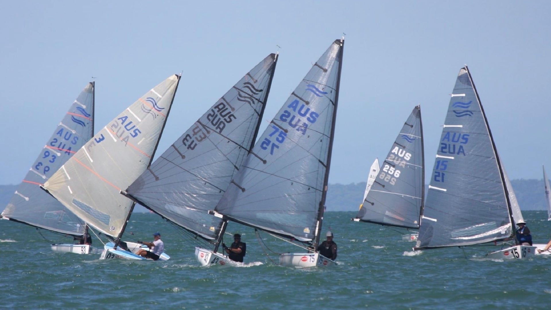 Finn class dinghies racing during a regatta start